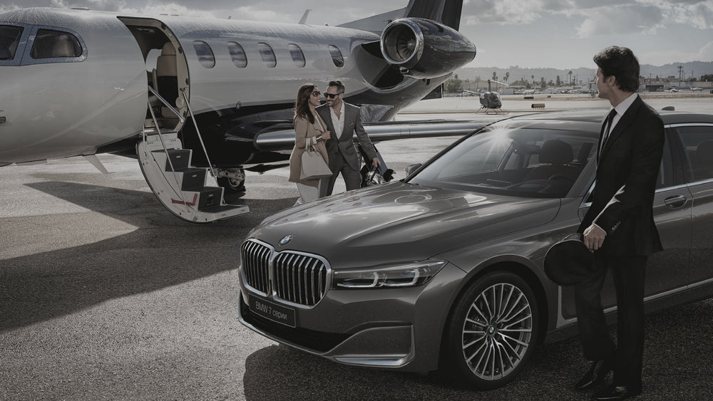 BMW car on a tarmac with a private jet and people in the background